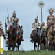 Soliders on horseback standing on a hill